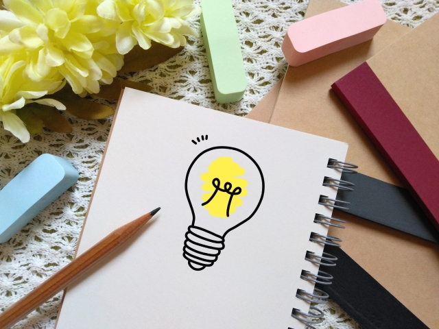ノートに電球のアイデアを描く様子